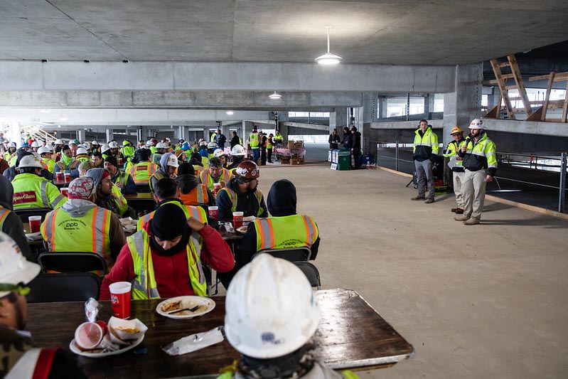 Members of the construction team that worked on the Highland campus Parking Garage attend a presentation during the topping out ceremony.