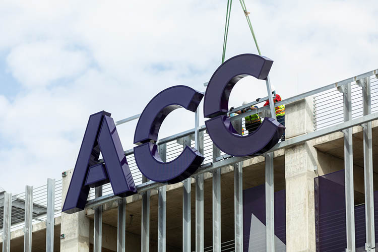 The letters ACC being installed on the East facing side of the Highland Campus parking garage.