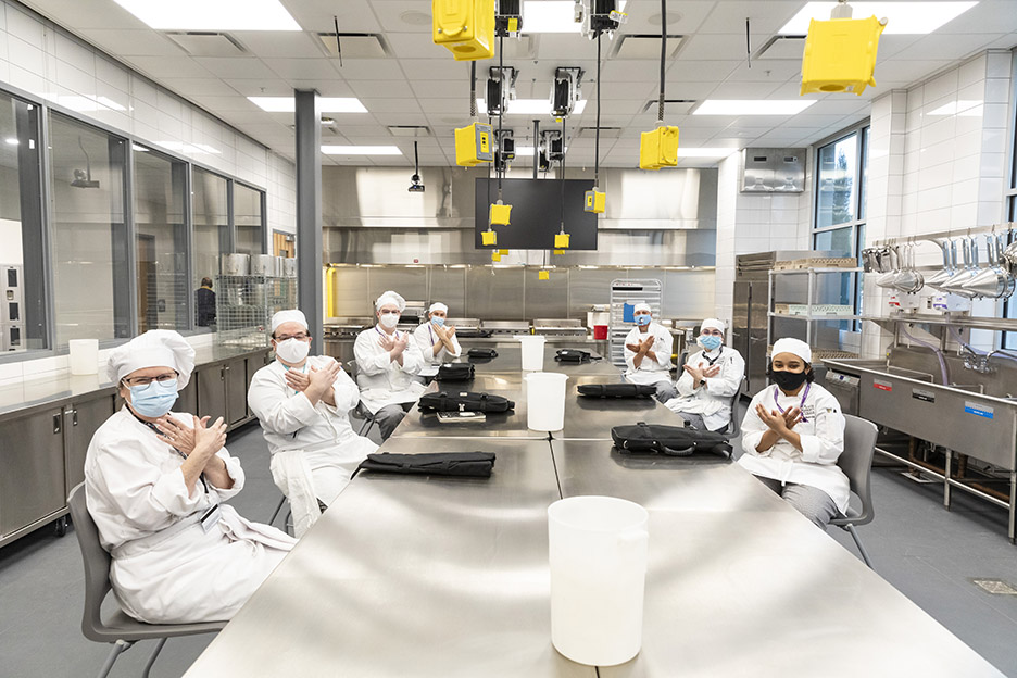 ACC Culinary Arts students pose for a photo in one of the commercial kitchens inside Highland Campus, Building 2000 where their first class of the spring 2021 semester, Meat Prep with Chef David Waggoner, is about to start.