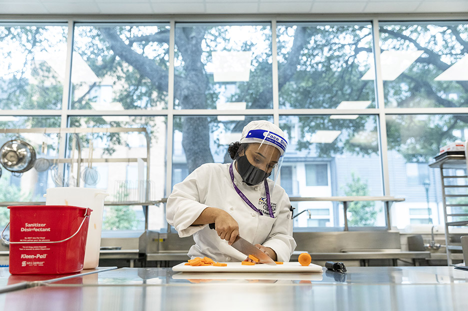 ACC Culinary Arts student Ora E. practices knife skills during her first class of the spring 2021 semester inside Highland Campus, Building 2000.
