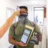 A student getting his temperature scanned.