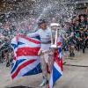 F1 racer Lewis Hamilton celebrating his 2015 win at COTA with trophy in hand and confetti falling around him